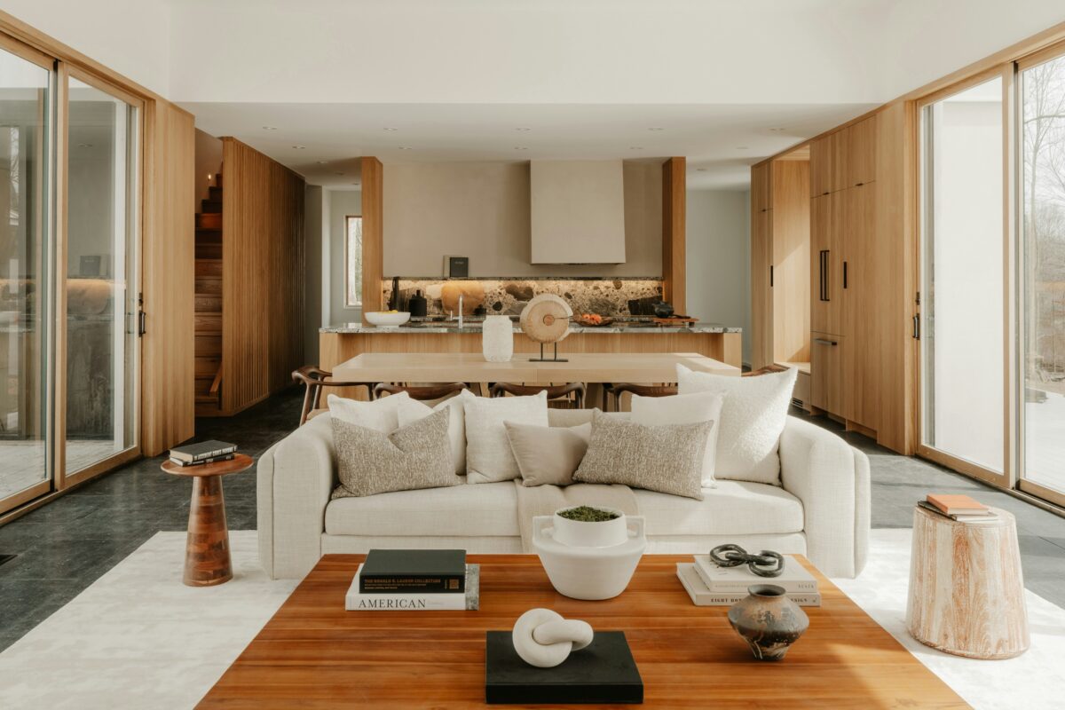 Minimalist open-concept living room and kitchen with light wood finishes.