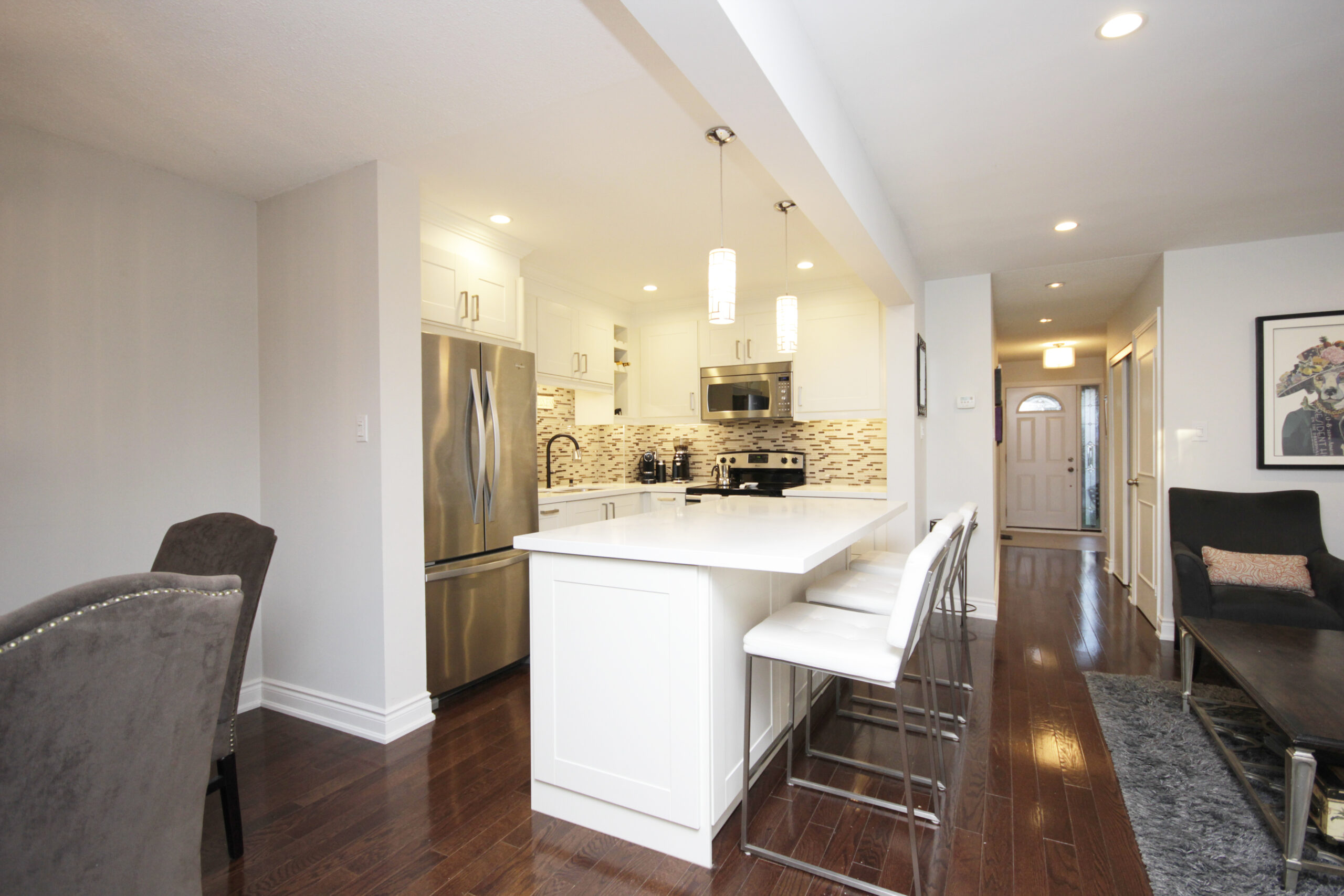 White kitchen with stainless steel appliances and an island