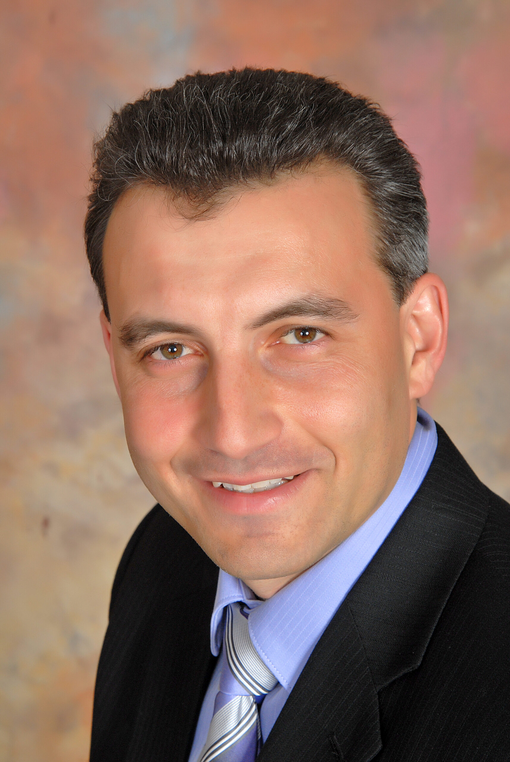 Eugene Feiguelman in a suit, blue shirt, and tie