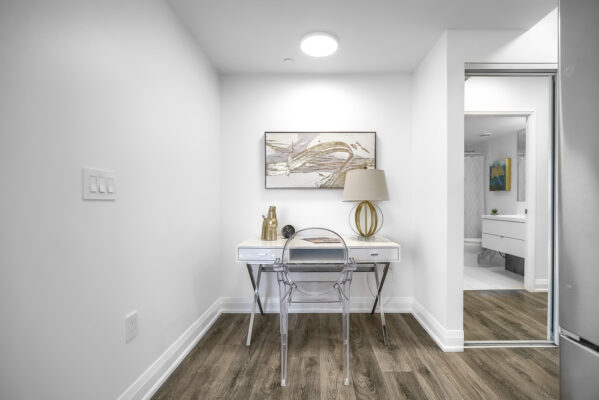 Den sized room with a desk, chair, and painting on the wall