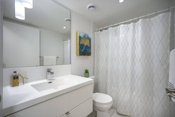 Modern bathroom with a mirror, sink, toilet, and bathtub