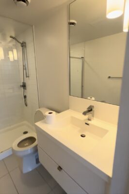 White modern bathroom with a sink, toilet, and shower