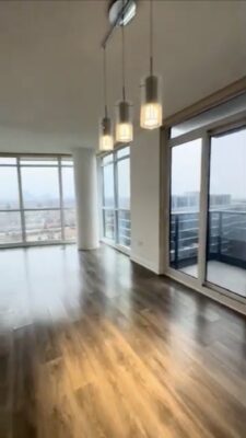 Empty open concept living and dining room and doors to the balcony
