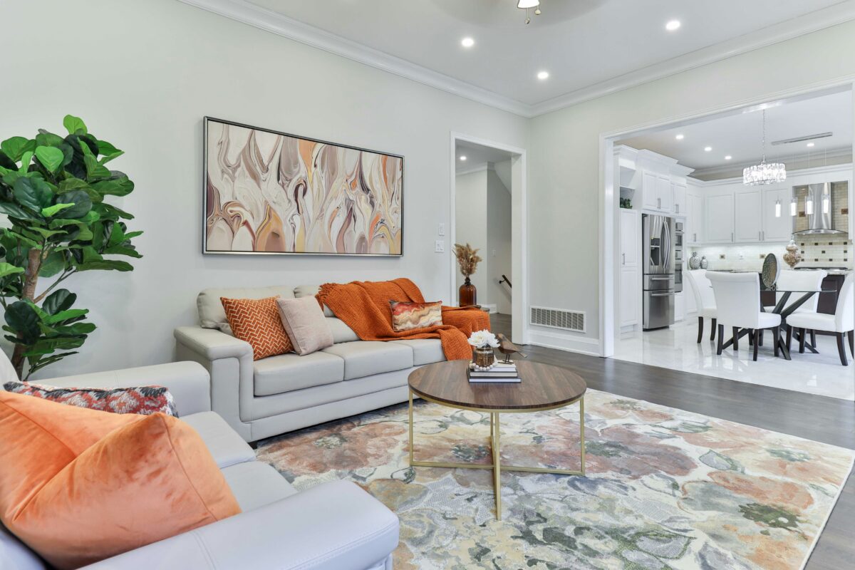 Contemporary living room with gray sofas, warm accents, and abstract wall art.
