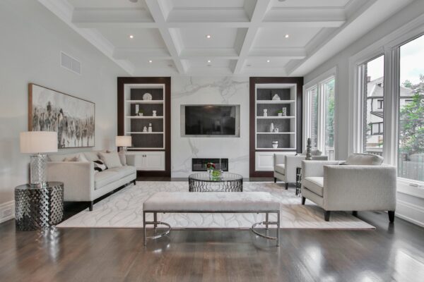 Elegant living room with marble feature wall, built-in shelves, and neutral seating.