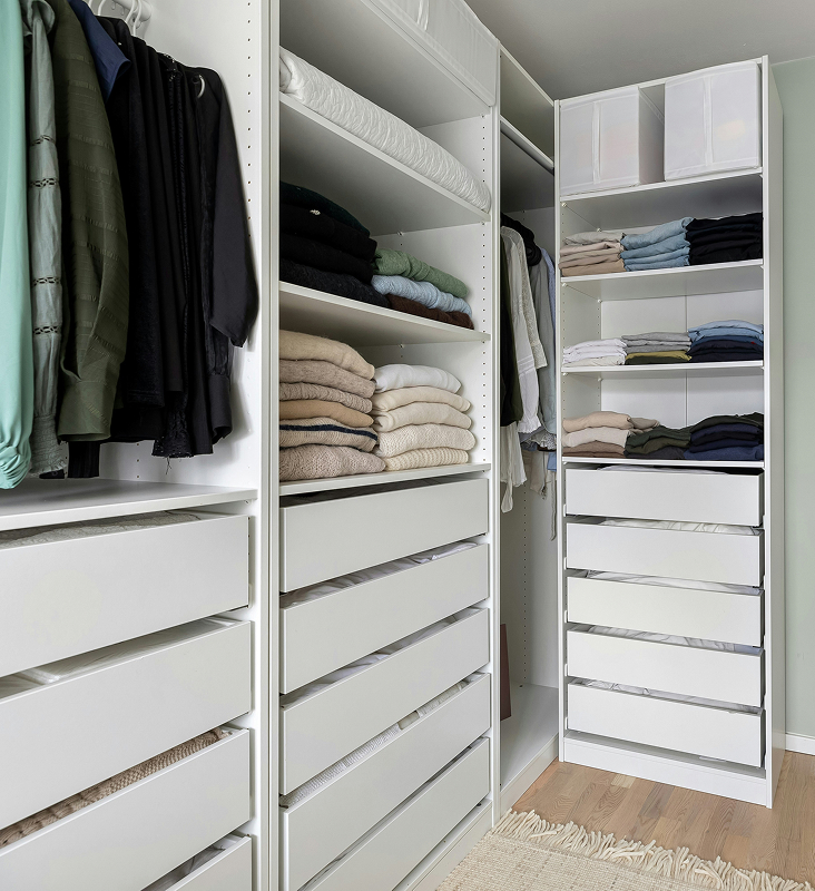 Organized walk-in closet with clothing and storage shelves